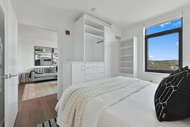 bedroom with dark wood-style flooring and visible vents