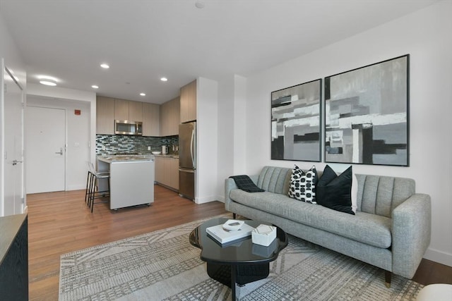 living room featuring recessed lighting, baseboards, and wood finished floors