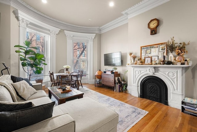 living room featuring ornamental molding, a fireplace, wood finished floors, and baseboards