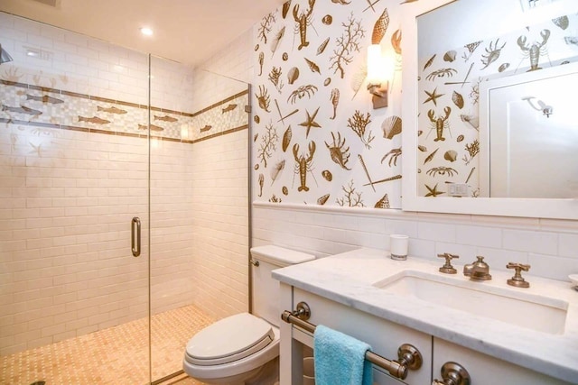 bathroom featuring tile walls, vanity, toilet, and an enclosed shower