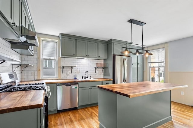 14 Horace St Unit 2, Boston, MA 02128 - kitchen featuring butcher block counters, appliances with stainless steel finishes, a sink, light wood finished floors, and pendant lighting