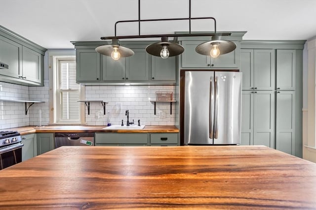 14 Horace St Unit 2, Boston, MA 02128 - kitchen with wooden counters, stainless steel appliances, a sink, green cabinetry, and decorative backsplash