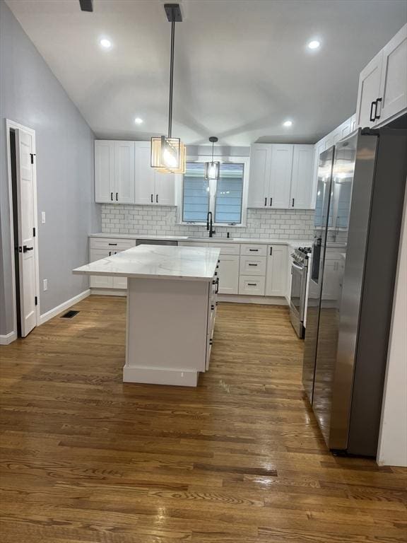 kitchen featuring sink, white cabinetry, decorative light fixtures, a kitchen island, and stainless steel appliances