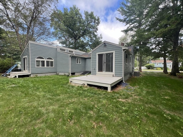 back of house featuring a deck, central AC unit, and a lawn