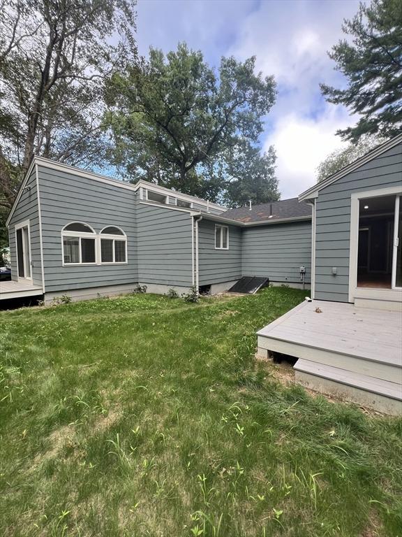 rear view of house with a wooden deck and a yard