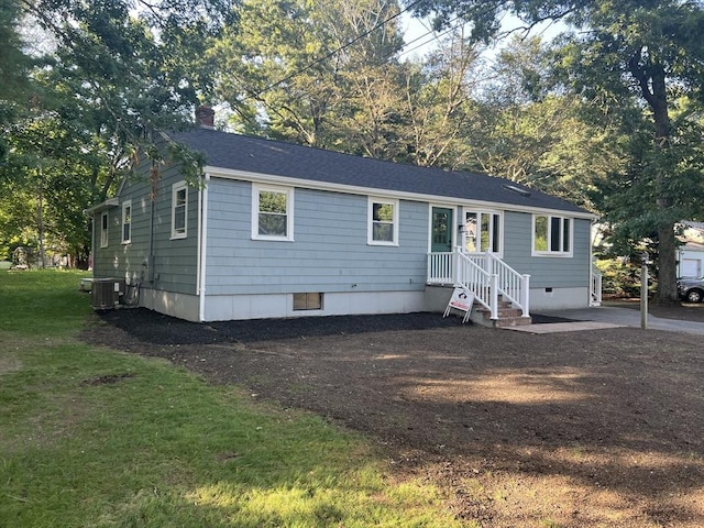 view of front of home with central AC unit and a front lawn