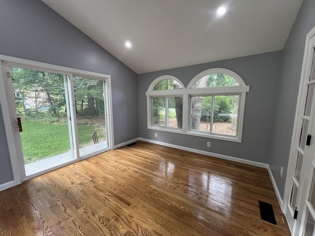 empty room featuring lofted ceiling and light hardwood / wood-style flooring