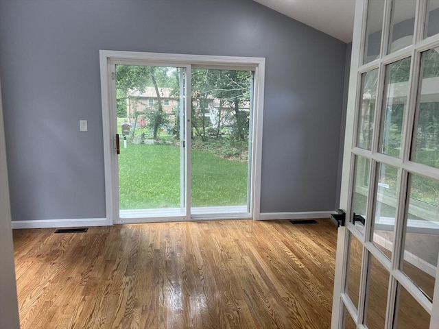 doorway with lofted ceiling and light hardwood / wood-style floors