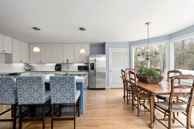 4 Old Meadow Ln, Harvard, MA 01451 - kitchen with decorative backsplash, stainless steel appliances, light wood-style flooring, and a notable chandelier