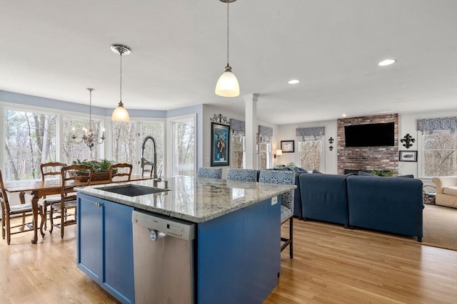 4 Old Meadow Ln, Harvard, MA 01451 - kitchen featuring a sink, blue cabinetry, light wood-style flooring, stainless steel dishwasher, and ornate columns
