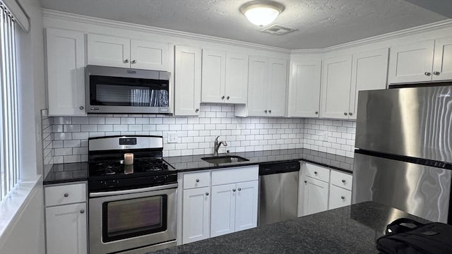 kitchen with tasteful backsplash, a textured ceiling, stainless steel appliances, sink, and white cabinets