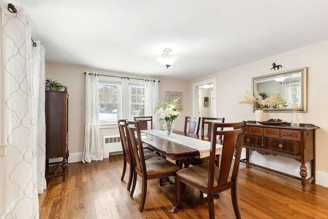 dining area featuring radiator and dark hardwood / wood-style flooring