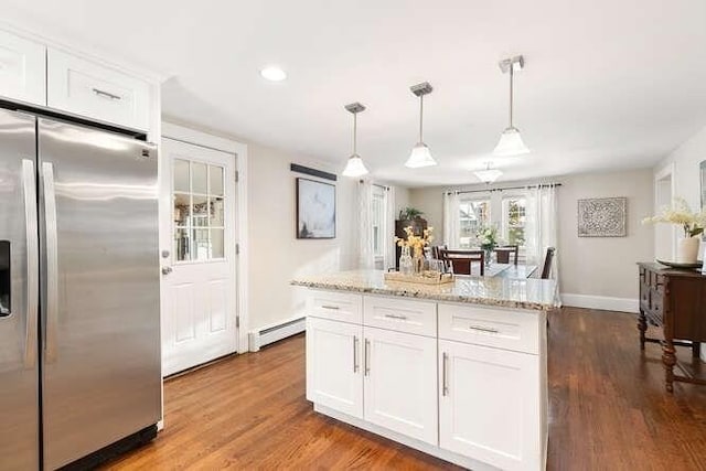 kitchen with white cabinets, a baseboard heating unit, hanging light fixtures, stainless steel fridge with ice dispenser, and hardwood / wood-style flooring