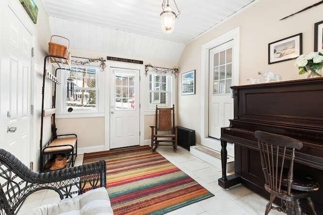 interior space featuring vaulted ceiling, radiator, and light tile patterned flooring