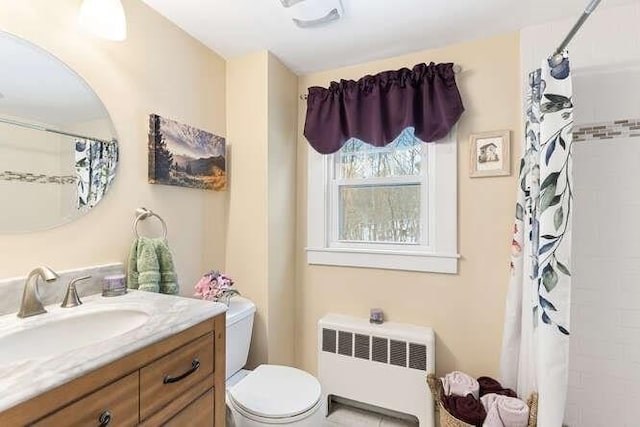 bathroom featuring vanity, toilet, radiator heating unit, and a shower with curtain