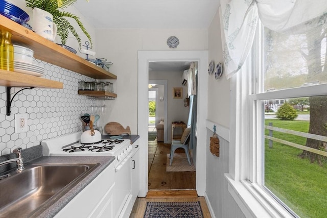 13 Hathaway St, Fairhaven, MA 02719 - kitchen featuring light wood-style floors, backsplash, white range with gas cooktop, open shelves, and a sink