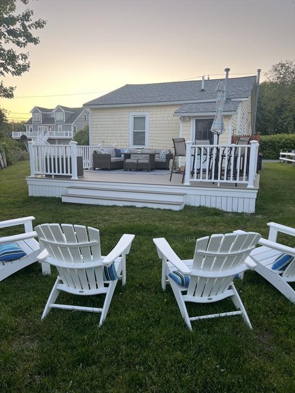 13 Hathaway St, Fairhaven, MA 02719 - back of house at dusk with an outdoor living space, a deck, a yard, and a shingled roof