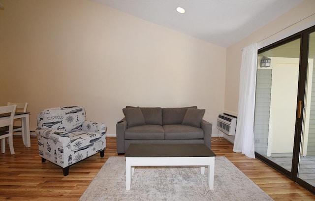 living room featuring a wall unit AC and light hardwood / wood-style flooring