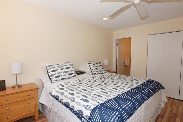 bedroom with dark hardwood / wood-style flooring, ceiling fan, and a closet