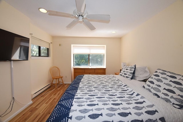 bedroom featuring ceiling fan, a baseboard radiator, multiple windows, and light hardwood / wood-style flooring