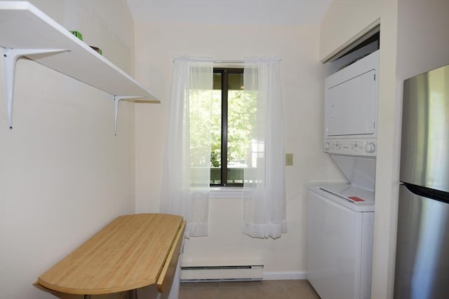 washroom featuring baseboard heating, stacked washer / drying machine, and tile patterned flooring