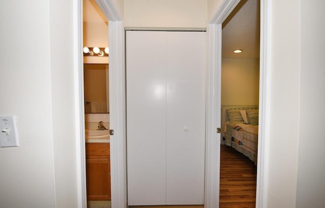 corridor with hardwood / wood-style flooring and sink