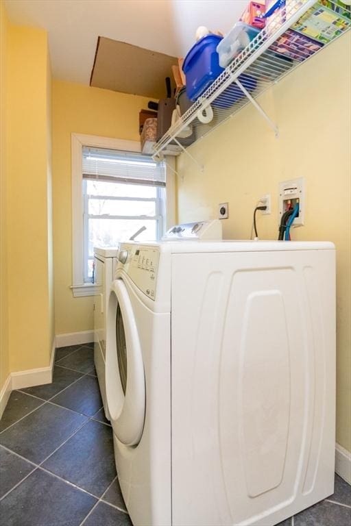 laundry room featuring laundry area, washer and clothes dryer, dark tile patterned floors, and baseboards