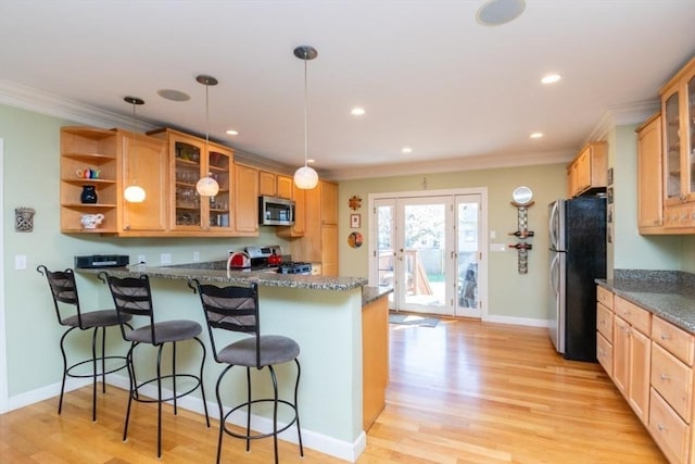 kitchen with ornamental molding, appliances with stainless steel finishes, a peninsula, and a kitchen bar