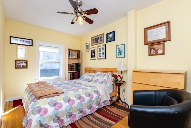 bedroom with baseboards, ceiling fan, and wood finished floors