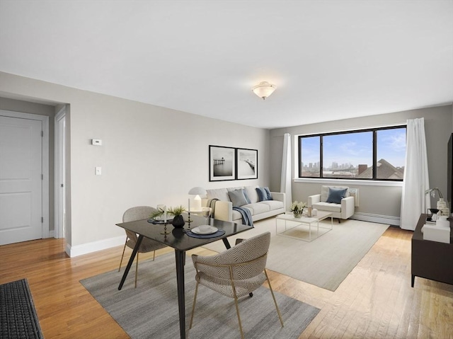 living room with light wood-type flooring, baseboards, and a baseboard radiator