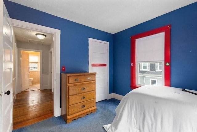 bedroom with baseboards and attic access