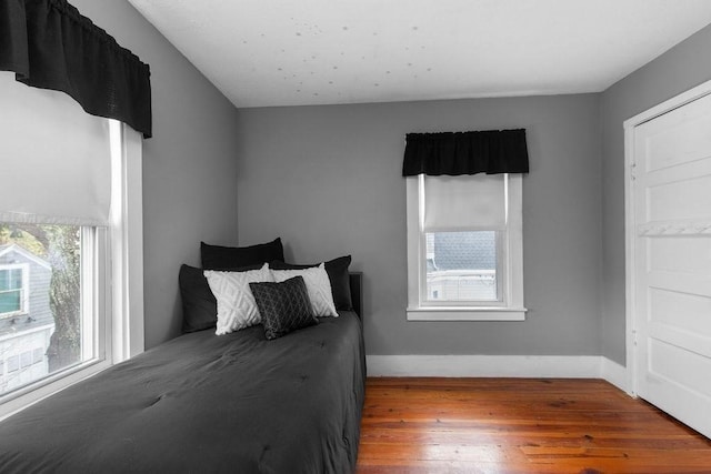 bedroom featuring baseboards and hardwood / wood-style flooring
