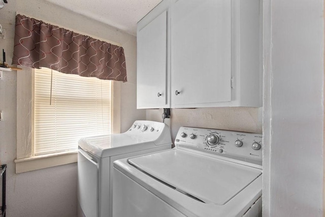 clothes washing area featuring cabinet space and washer and dryer