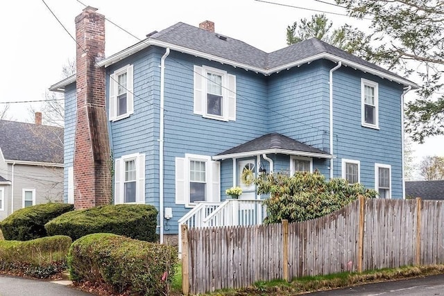 view of front of home featuring fence and a chimney