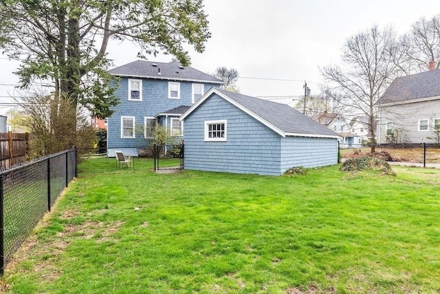 rear view of house with a lawn and a fenced backyard