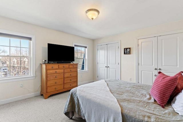 carpeted bedroom with multiple windows and multiple closets