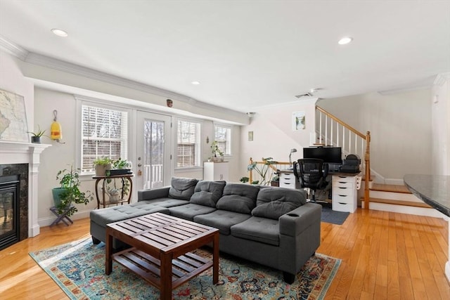 living room with a premium fireplace, crown molding, and hardwood / wood-style floors