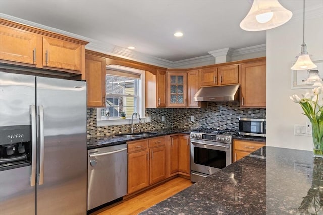 kitchen featuring backsplash, dark stone countertops, pendant lighting, sink, and appliances with stainless steel finishes