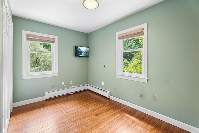 6 Fruit St, Hopkinton, MA 01748 - empty room featuring healthy amount of natural light, wood-type flooring, and a baseboard heating unit