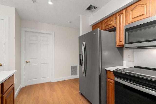 kitchen with light countertops, stainless steel microwave, visible vents, and black electric range oven