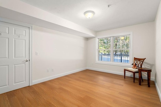 unfurnished room featuring baseboards and light wood finished floors