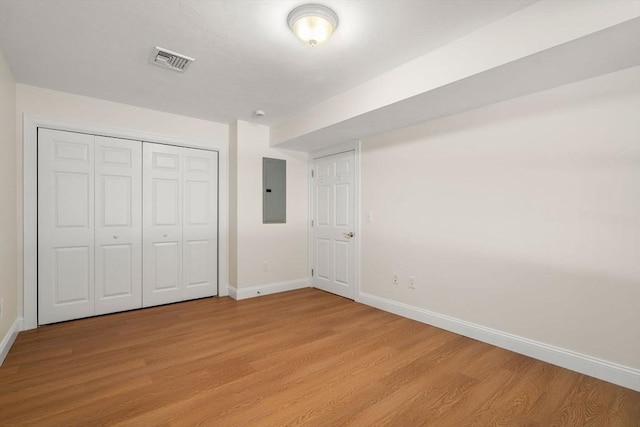 unfurnished bedroom with baseboards, electric panel, visible vents, and light wood-style floors