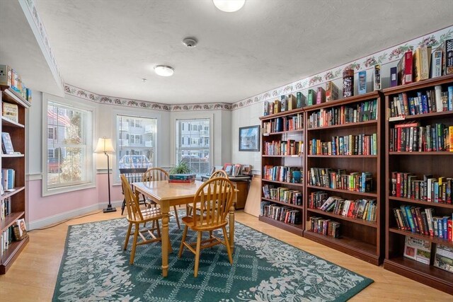 dining space featuring light wood finished floors and baseboards