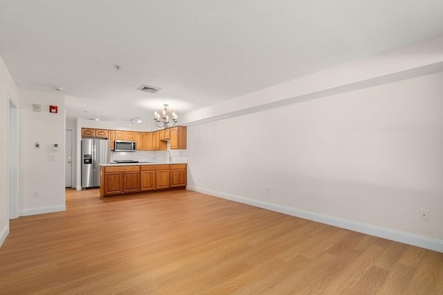 kitchen with visible vents, open floor plan, stainless steel appliances, light countertops, and light wood-type flooring