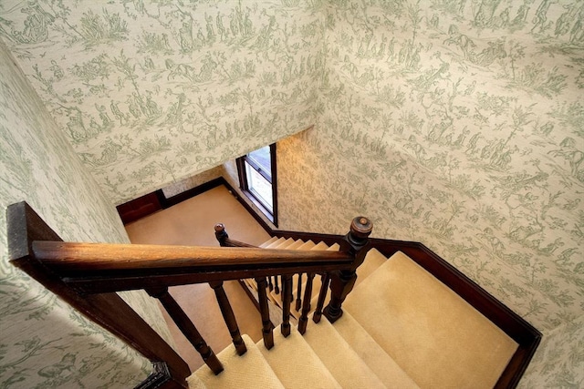 stairway featuring wallpapered walls