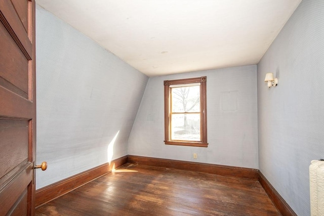 bonus room with baseboards, lofted ceiling, and hardwood / wood-style floors