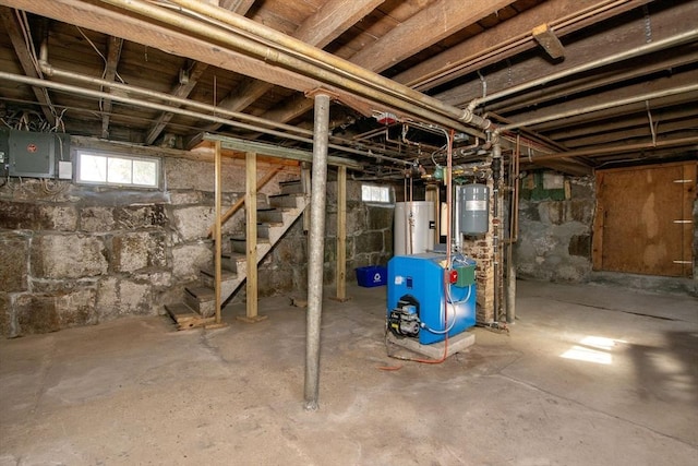 basement featuring stairs, electric panel, a heating unit, and water heater