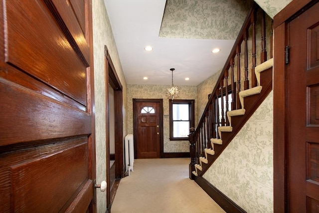 entryway with light carpet, radiator, stairs, and wallpapered walls