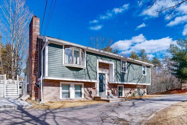 split foyer home with brick siding and a chimney