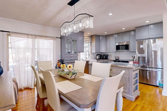 dining space with recessed lighting, light wood-type flooring, and crown molding